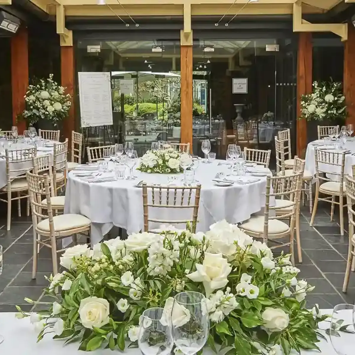 A room furnished with tables, chairs, and adorned with flowers.