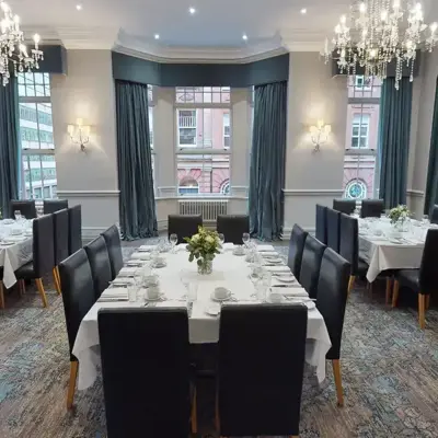 A dining room featuring elegantly arranged tables and chairs, adorned with exquisite chandeliers.