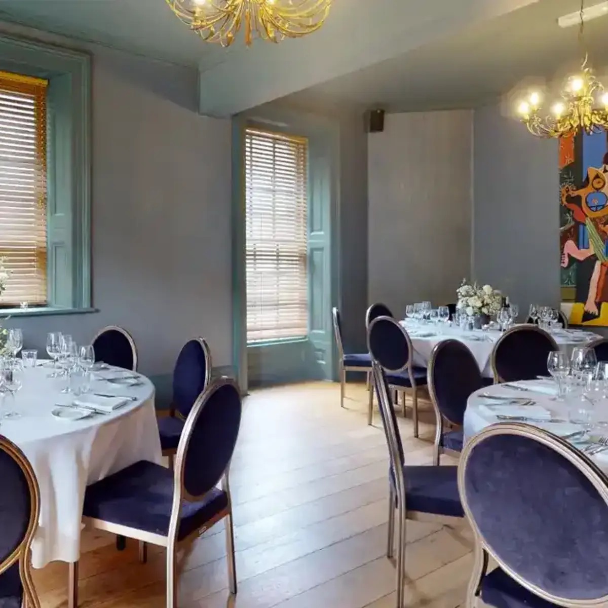 Dining room with round back chairs and gold chandelier 