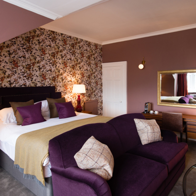 Bedroom featuring a purple couch and mirror