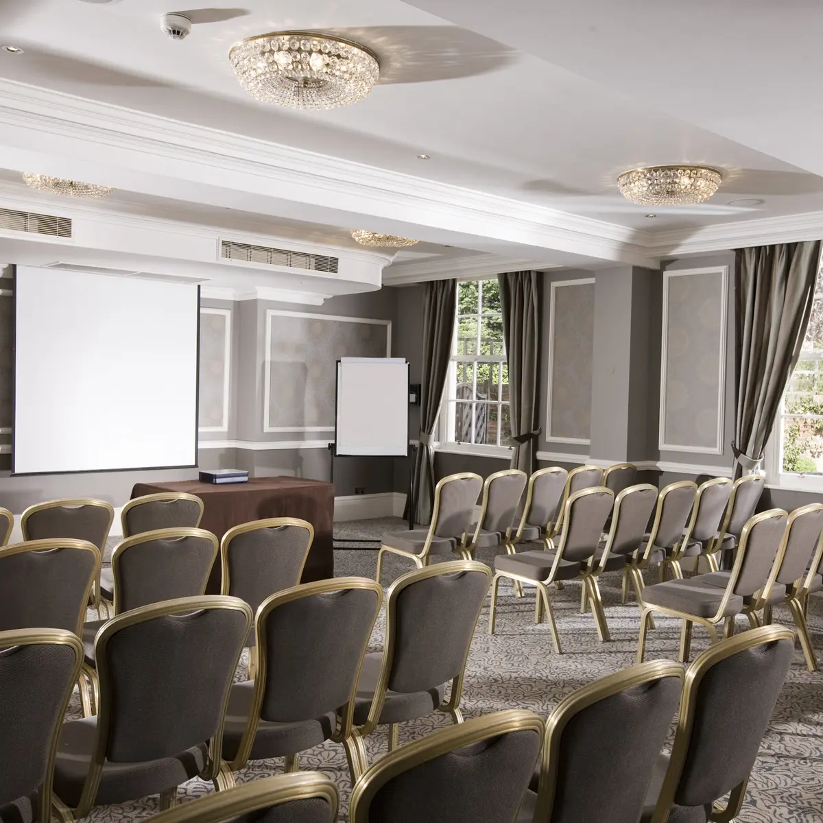 Conference room featuring chairs and a projector screen.