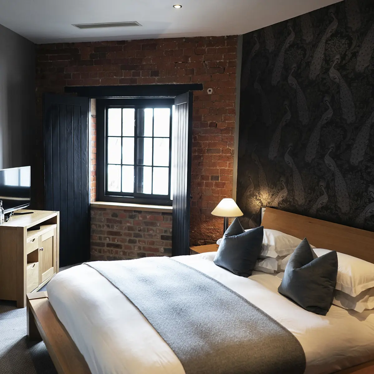 Bedroom featuring a brick wall and a bed.