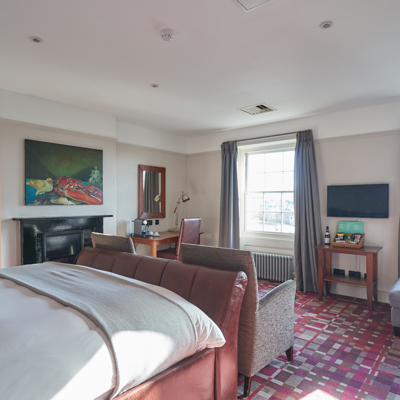 Spacious bedroom featuring a king-sized bed and an elegant fireplace.