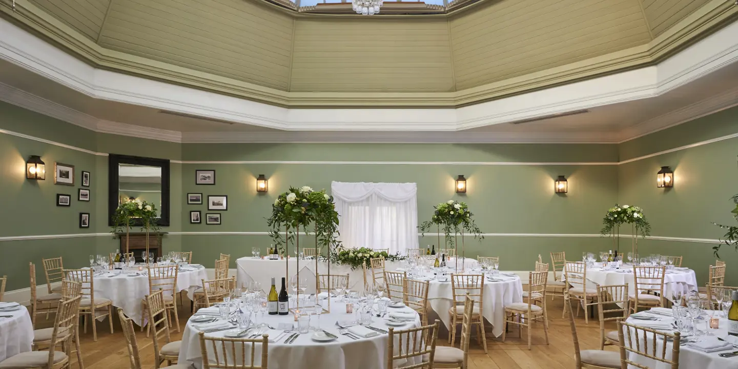 A dining room with numerous of round tables and chairs.