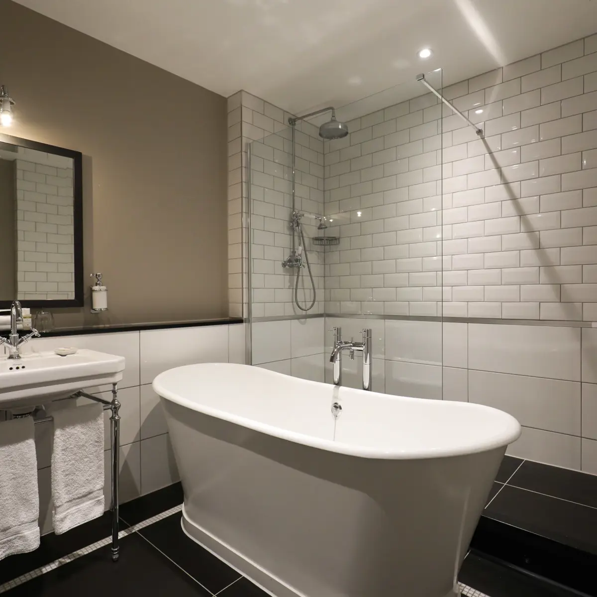 White bathtub positioned alongside a sink beneath a mirror.