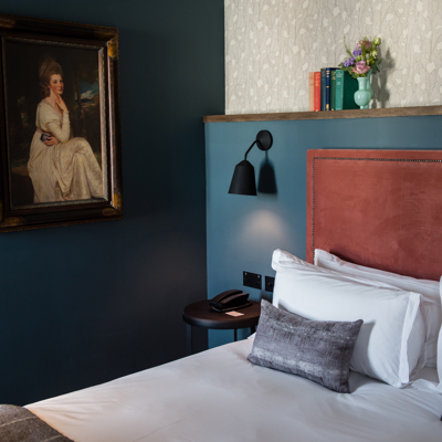 Bedroom featuring a comfortable bed and an elegant wall painting.